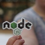 A person holding a Node.js sticker with a blurred background, close-up shot.